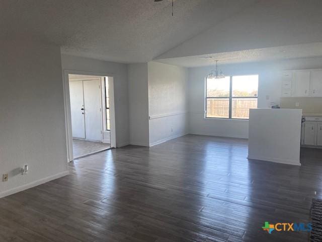 unfurnished room featuring lofted ceiling, dark hardwood / wood-style flooring, a textured ceiling, and a chandelier