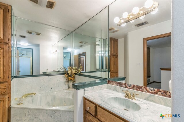 bathroom featuring vanity and a relaxing tiled tub