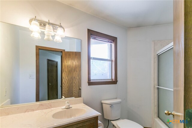 full bathroom with vanity, combined bath / shower with glass door, and toilet