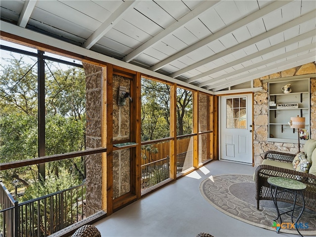 sunroom / solarium featuring lofted ceiling with beams