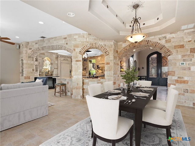 dining space featuring ceiling fan and a tray ceiling