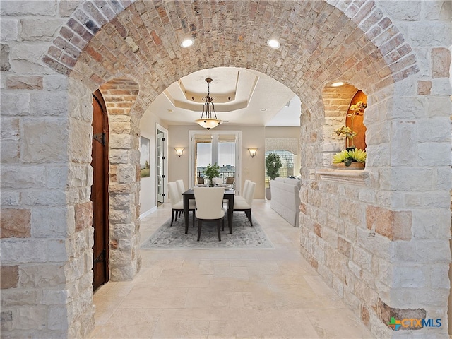 unfurnished dining area with a tray ceiling