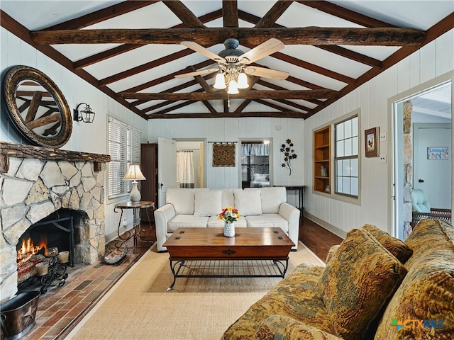 living room with ceiling fan, vaulted ceiling with beams, and a fireplace