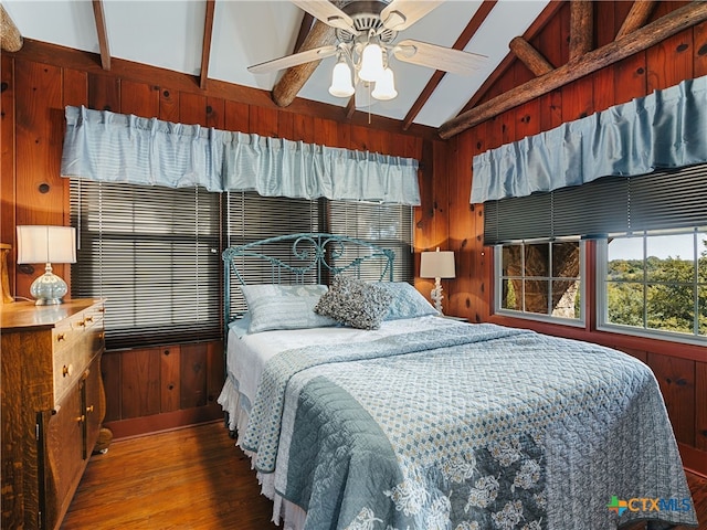 bedroom featuring ceiling fan, vaulted ceiling with beams, dark hardwood / wood-style flooring, and wood walls