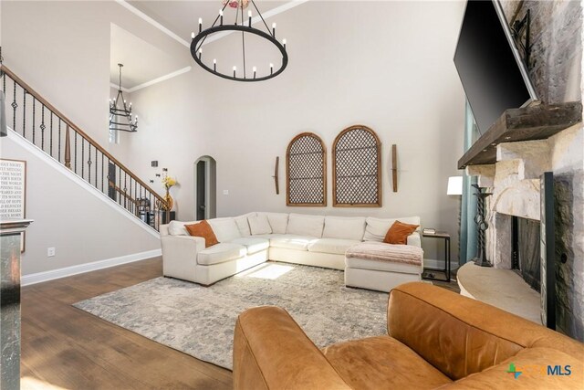 2015 Th Jones Mill Way, Salado, TX 76571 - living room featuring a chandelier, wood finished floors, a fireplace, a towering ceiling, and baseboards