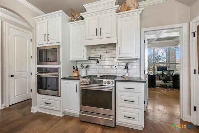 2015 Th Jones Mill Way, Salado, TX 76571 - kitchen featuring stainless steel appliances, dark countertops, tasteful backsplash, white cabinetry, and dark wood-style flooring
