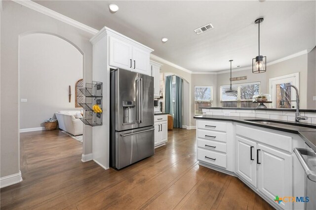 2015 Th Jones Mill Way, Salado, TX 76571 - kitchen featuring stainless steel appliances, arched walkways, a sink, dark countertops, and dark wood-type flooring