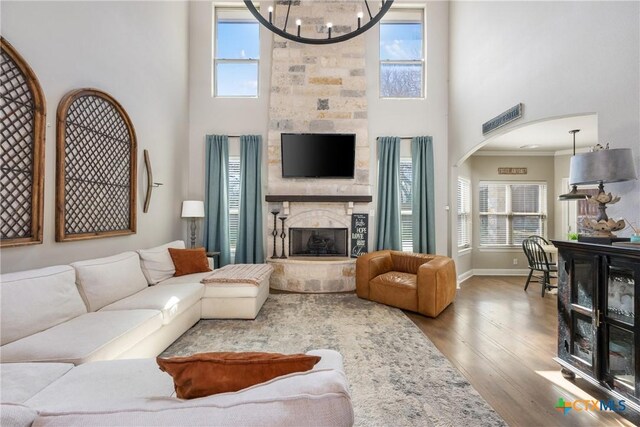 2015 Th Jones Mill Way, Salado, TX 76571 - living room featuring a fireplace, a towering ceiling, wood finished floors, a chandelier, and baseboards