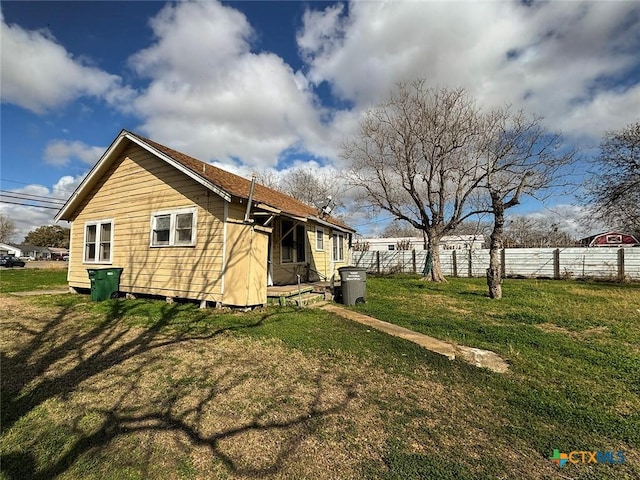 rear view of property featuring a yard