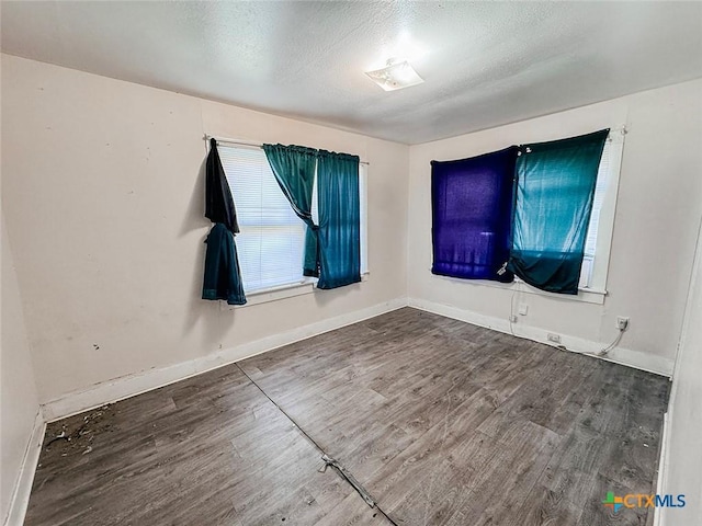 spare room featuring hardwood / wood-style floors and a textured ceiling