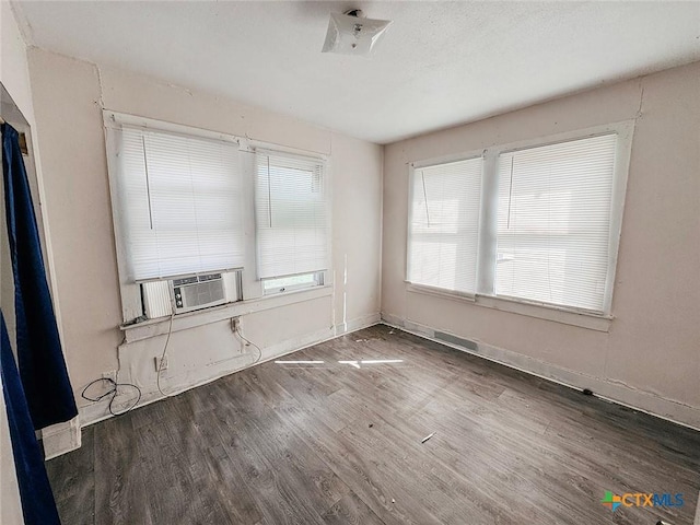 spare room featuring cooling unit and dark hardwood / wood-style floors