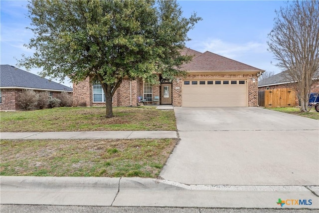 view of front facade featuring a front yard, fence, an attached garage, concrete driveway, and brick siding