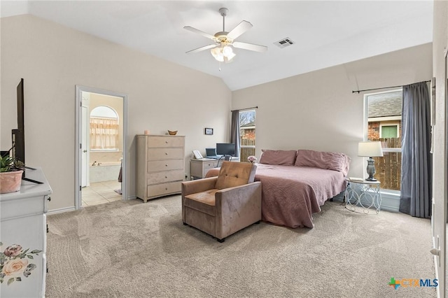 bedroom with visible vents, light colored carpet, connected bathroom, and lofted ceiling