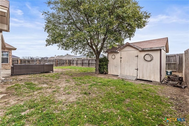 view of yard featuring an outbuilding, a storage unit, and a fenced backyard