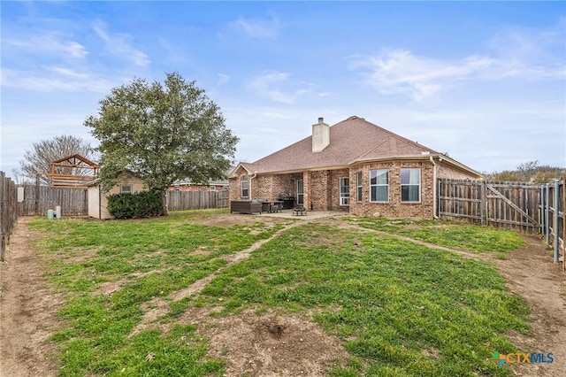 rear view of house featuring brick siding, a patio, and a fenced backyard