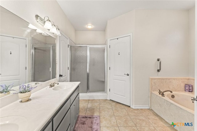 full bath featuring double vanity, a stall shower, a sink, tile patterned flooring, and a garden tub