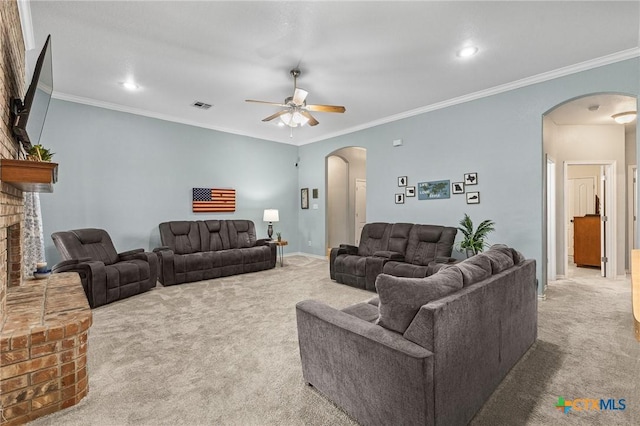 carpeted living room with arched walkways, a brick fireplace, and ornamental molding