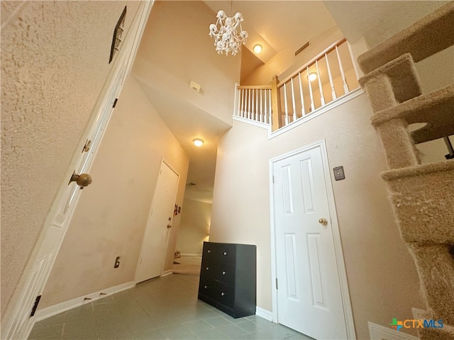 staircase featuring high vaulted ceiling and a notable chandelier