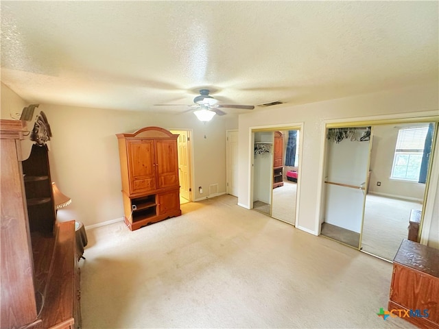 living room featuring a textured ceiling, light carpet, and ceiling fan