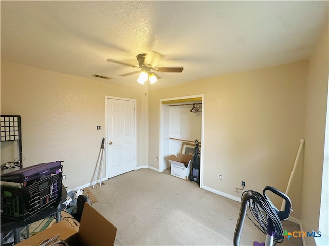 miscellaneous room with a textured ceiling, ceiling fan, and carpet floors