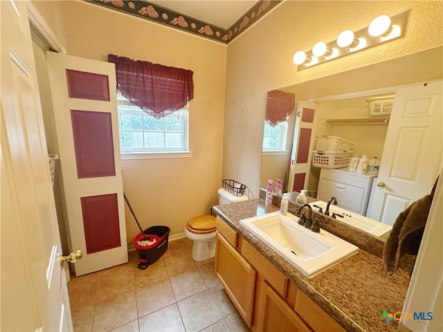 bathroom with toilet, vanity, tile patterned floors, and washer / dryer