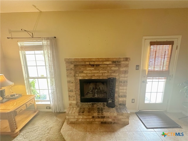 interior space with a fireplace, a wealth of natural light, and tile patterned floors