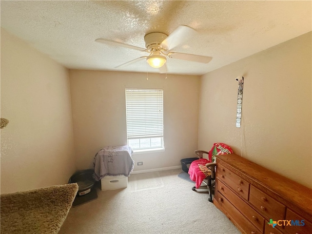 bedroom with carpet, a textured ceiling, and ceiling fan