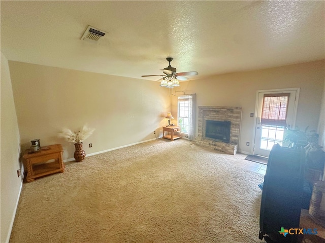 unfurnished living room featuring carpet flooring, a fireplace, a textured ceiling, and ceiling fan