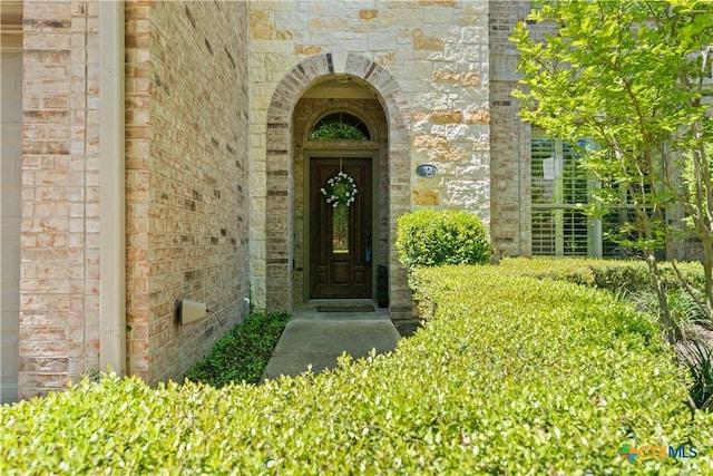 entrance to property with stone siding and brick siding