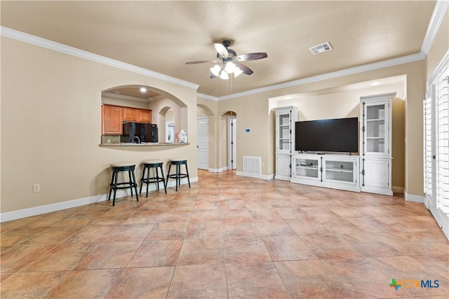 living area with ornamental molding, baseboards, a ceiling fan, and visible vents