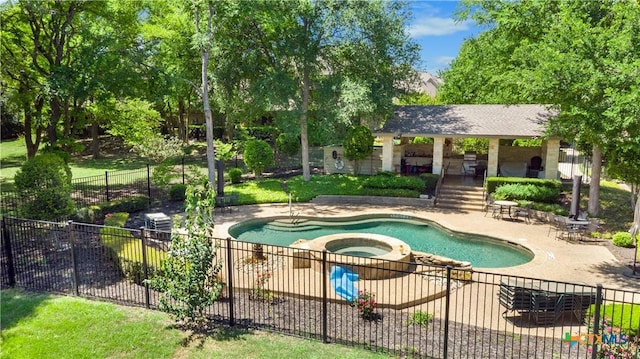 view of swimming pool with a patio area, a pool with connected hot tub, and fence