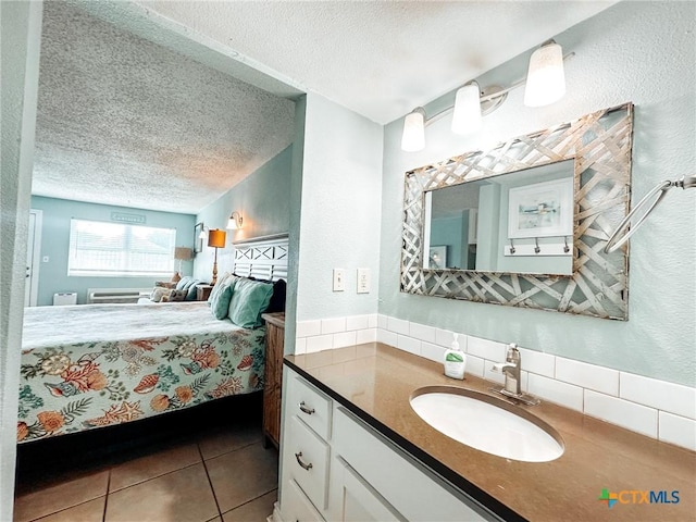 407 Beach Ave Unit 111, Port Aransas, TX 78373 - bathroom featuring a textured ceiling, connected bathroom, vanity, tile patterned floors, and decorative backsplash
