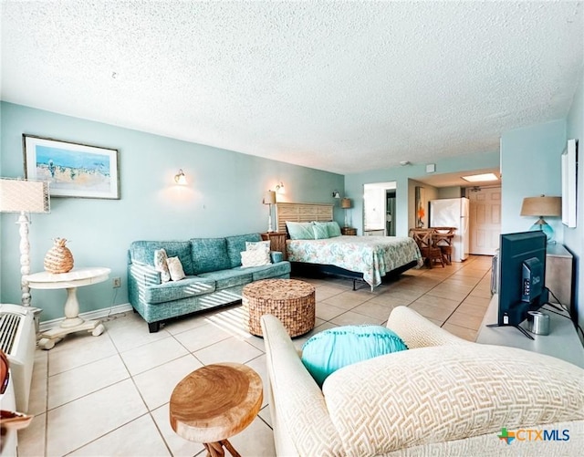 407 Beach Ave Unit 111, Port Aransas, TX 78373 - tiled bedroom with freestanding refrigerator and a textured ceiling
