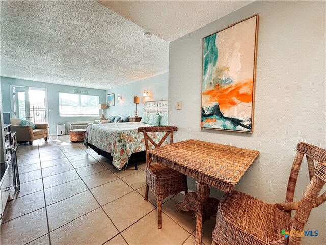 bedroom featuring light tile patterned flooring and a textured ceiling