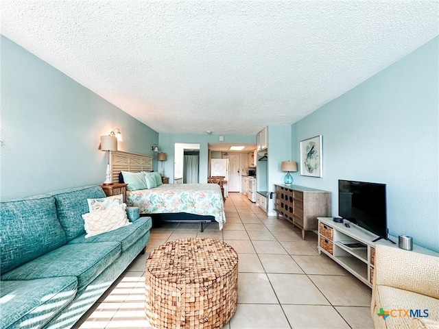 407 Beach Ave Unit 111, Port Aransas, TX 78373 - bedroom with a textured ceiling and light tile patterned floors