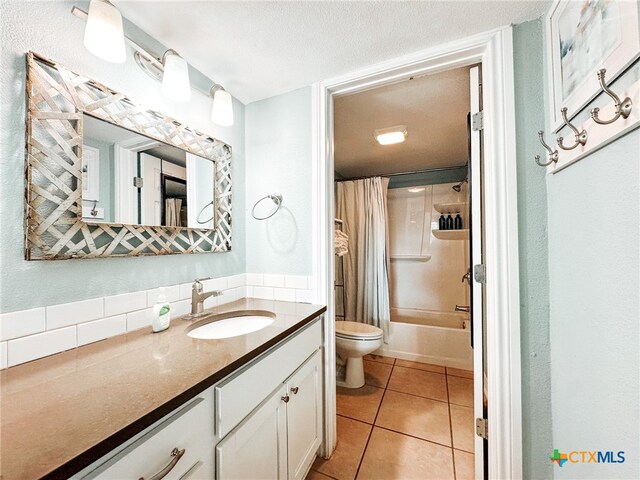 full bathroom with shower / bath combination with curtain, a textured ceiling, vanity, tile patterned floors, and toilet