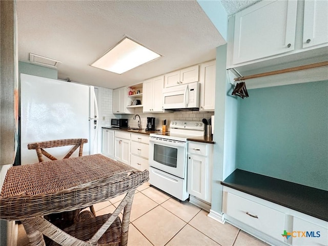 407 Beach Ave Unit 111, Port Aransas, TX 78373 - kitchen with white appliances, dark countertops, a sink, open shelves, and tasteful backsplash