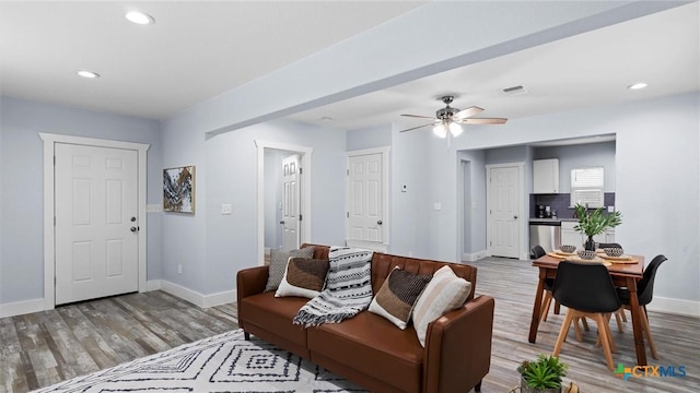 living room featuring ceiling fan and light hardwood / wood-style flooring