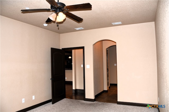 unfurnished bedroom with ceiling fan, dark wood-type flooring, and a textured ceiling