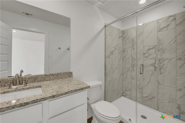 bathroom with vanity, toilet, and a shower with shower door