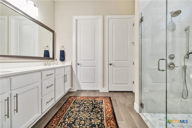 bathroom featuring vanity, hardwood / wood-style floors, and a shower with shower door