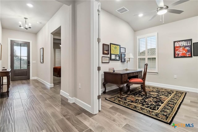 office area featuring ceiling fan with notable chandelier and hardwood / wood-style floors