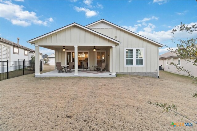 back of property with ceiling fan, a patio, and a lawn