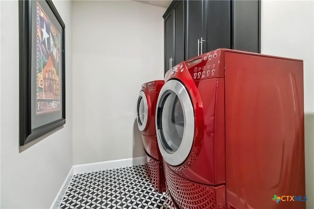 laundry room featuring washer and clothes dryer and cabinets