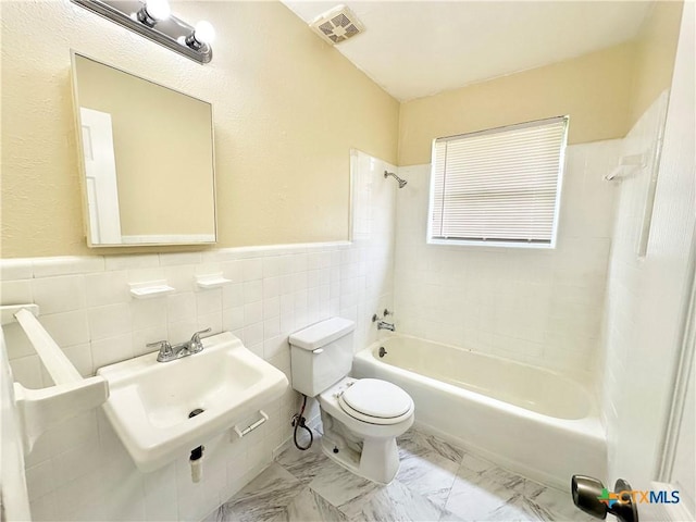 502 S 13th St, Copperas Cove, TX 76522 - full bathroom with toilet, shower / washtub combination, tile walls, a wainscoted wall, and a sink