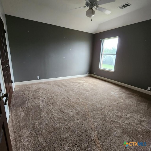 spare room with lofted ceiling, ceiling fan, and carpet