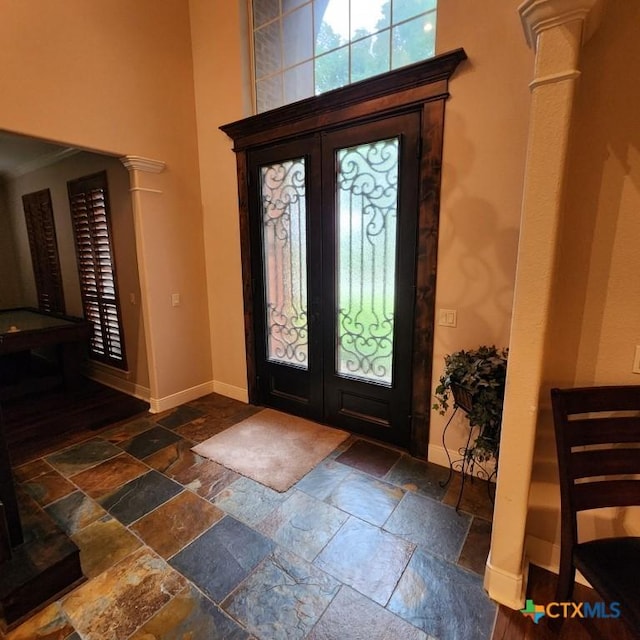 11710 Uplands Ridge Dr, Austin, TX 78738 - entrance foyer featuring stone tile flooring, baseboards, a towering ceiling, ornate columns, and french doors