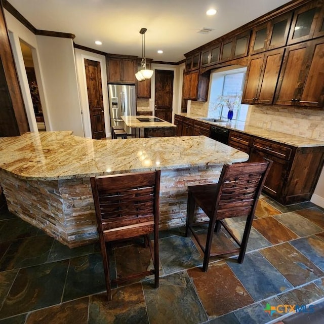 kitchen featuring a kitchen island, decorative light fixtures, decorative backsplash, black appliances, and crown molding