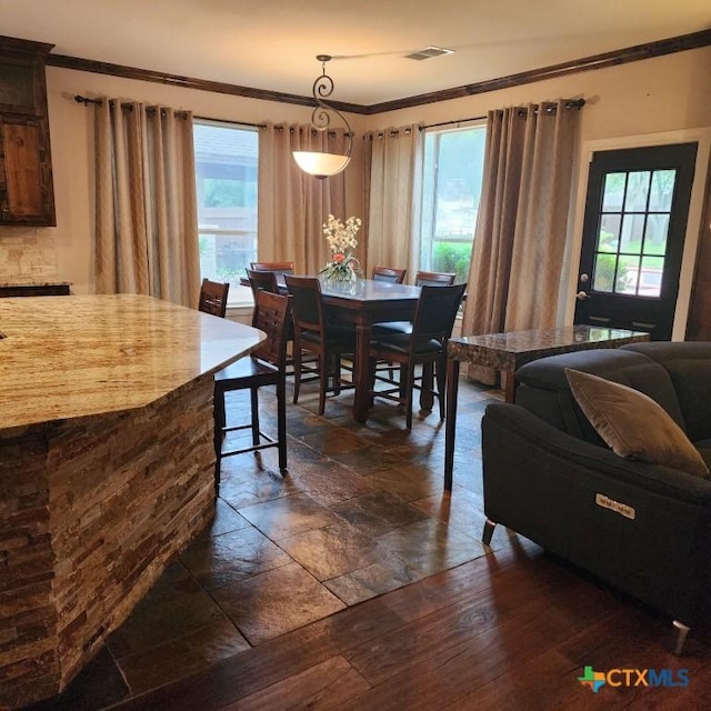 dining area featuring ornamental molding and dark hardwood / wood-style floors