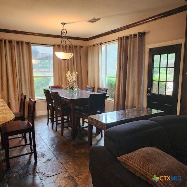 dining area with crown molding and plenty of natural light